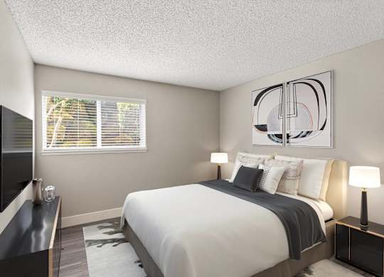 A bedroom with a large bed and a television on the wall.