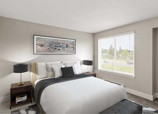 A bedroom with a large bed, a nightstand with a lamp, and a framed picture on the wall.