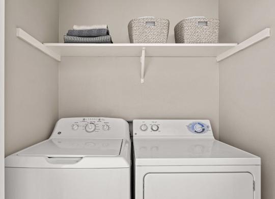 Two white washing machines in a laundry room.