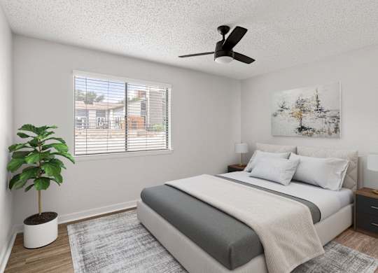 A bedroom with a bed, nightstand, and a plant.