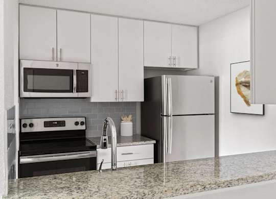 A modern kitchen with a granite countertop and stainless steel appliances.