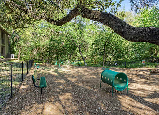 A playground with a green slide and a green bench.