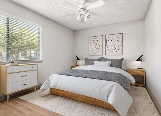 A bedroom with a bed, nightstands, and a ceiling fan.