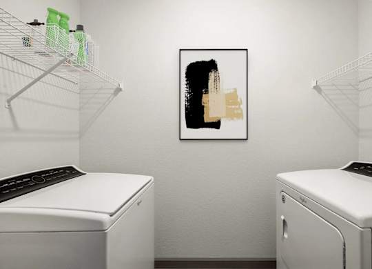 A laundry room with two washing machines and a picture on the wall.
