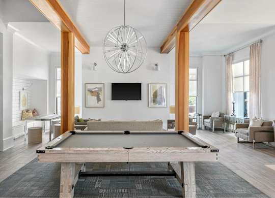 A pool table is in the middle of a room with a television and a couch.
