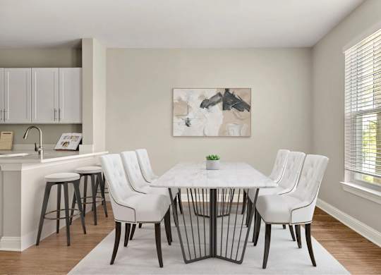 A dining room with a white table and chairs.
