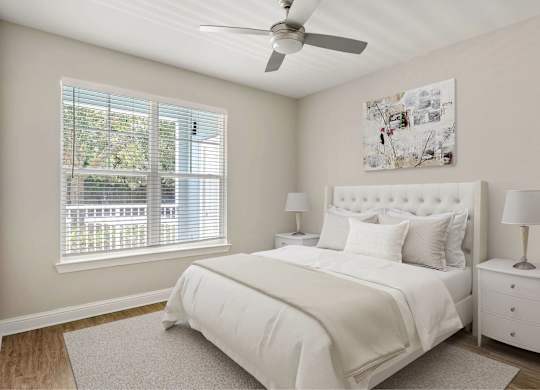 A bedroom with a window and ceiling fan.