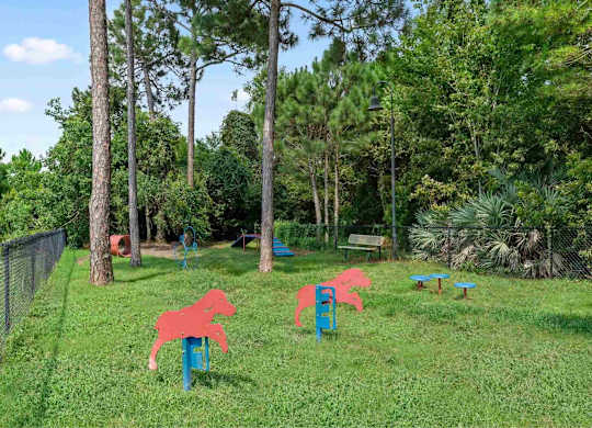 A playground with a red horse and a blue horse.