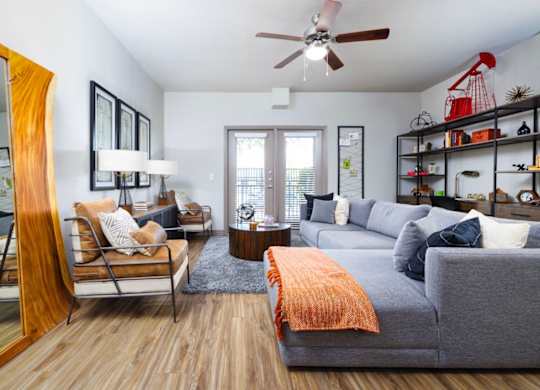 A living room with a grey couch, a wooden chair, and a coffee table.