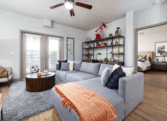 A living room with a grey couch and a wooden coffee table.