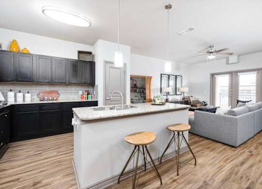 A kitchen with a bar and a couch in the living room.