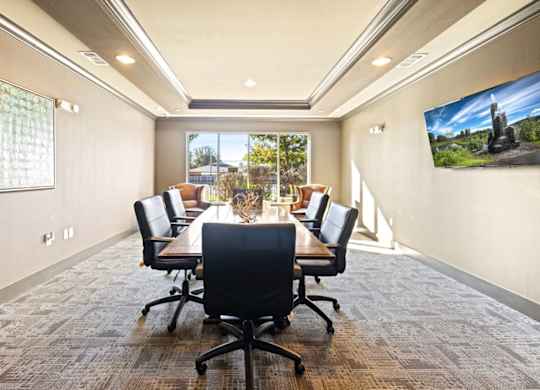 A conference room with a long table and chairs.