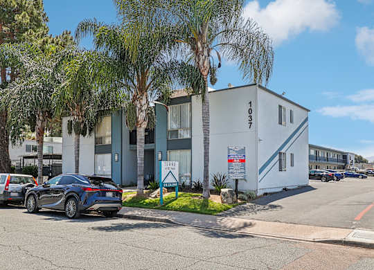 A modern building with the number 1937 on it is surrounded by palm trees.