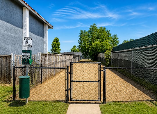 A black gate blocks the entrance to a driveway.