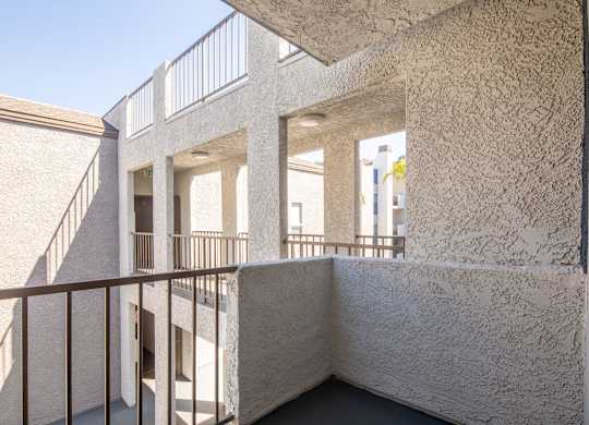 A white building with a balcony and a staircase.