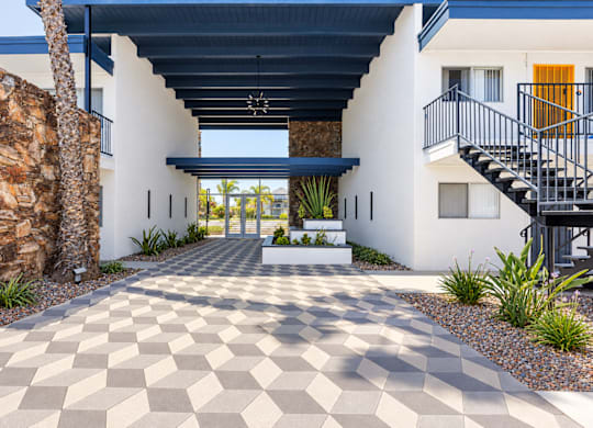 A modern house with a checkered floor leading to the front door.