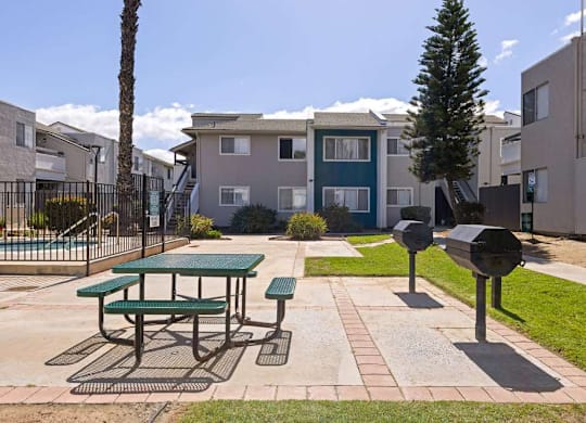 A green picnic table is in the middle of a courtyard.