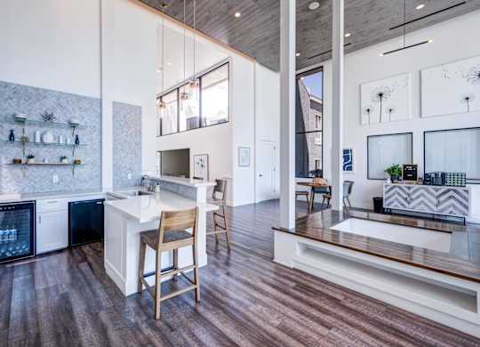 A kitchen with a white counter top and wooden floors.