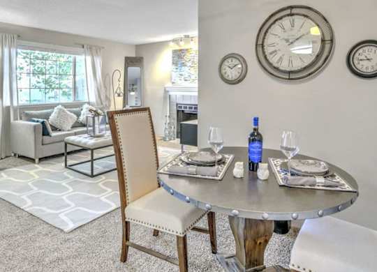 A dining room with a table set for two and a ceiling fan.