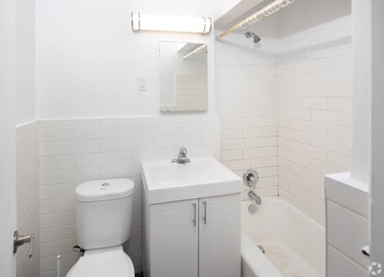 A white toilet sits next to a sink in a small bathroom.
