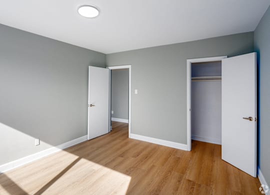A room with a white door and a white cabinet with a light on the ceiling.