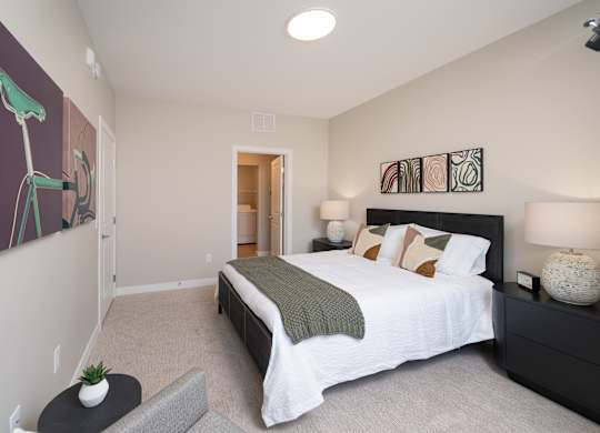 A bedroom with a large bed and a painting of a bicycle on the wall.
