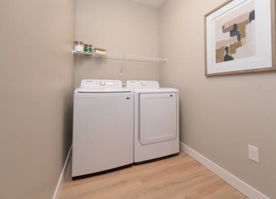 Two white washing machines in a laundry room.