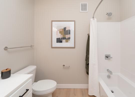 A bathroom with a toilet, a bathtub, and a shower curtain.