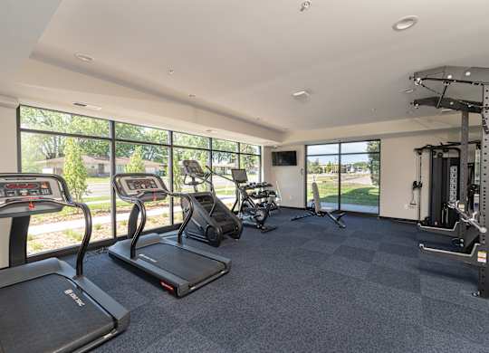 A spacious fitness center with treadmills, elliptical machines, and other exercise equipment.