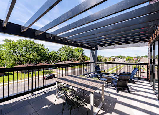 A patio with a table and chairs under a roof.
