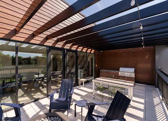 A patio with a table and chairs under a roof.