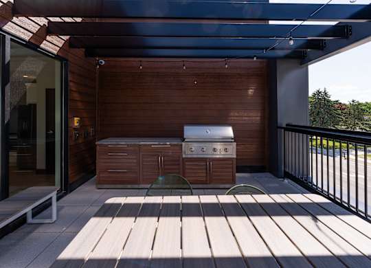 A patio with a table and chairs under a roof.