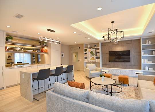 A modern living room with a grey sofa and a bar area at Roxy Apartments, Hamilton, Ontario