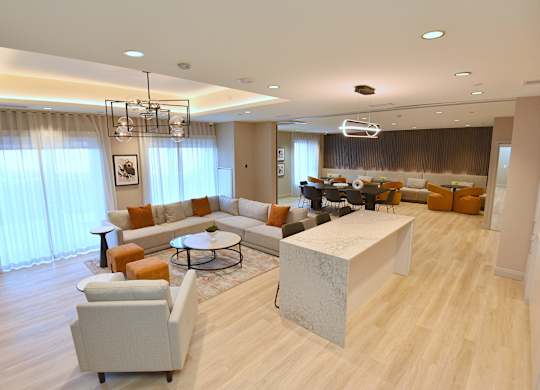 A modern living room with a large grey sofa and a white coffee table at Roxy Apartments, Hamilton