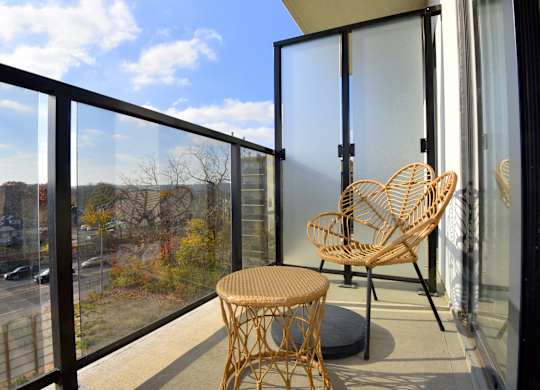 A balcony with a chair and table at Roxy Apartments, Hamilton, ON, L8H 0B7