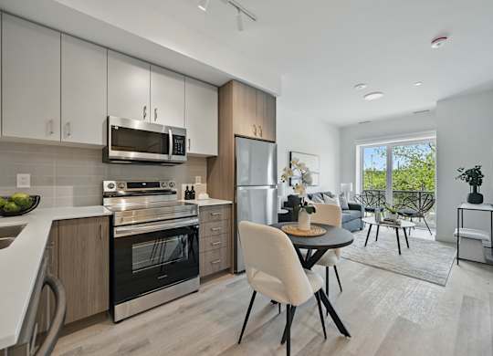 A modern kitchen with a dining table and chairs at Roxy Apartments, Ontario, L8H 0B7