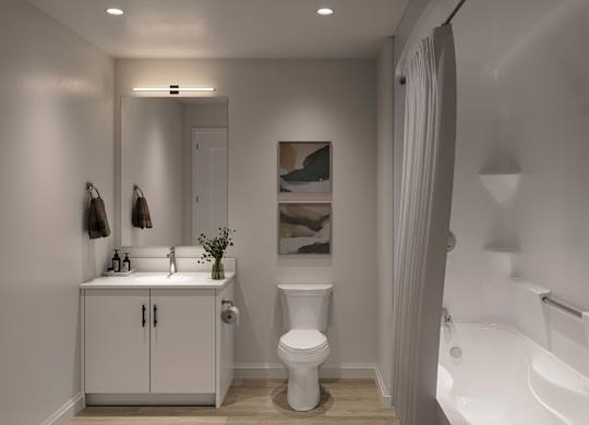 A white bathroom with a toilet, sink, and bathtub at Roxy Apartments, Hamilton, ON, L8H 0B7