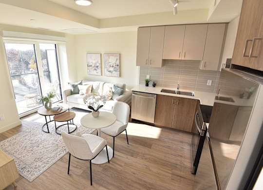 A kitchen with a white couch and a table with chairs at Roxy Apartments, Hamilton, Ontario