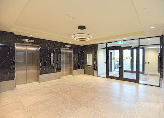 A spacious lobby with marble floors and a ceiling light at Roxy Apartments, Ontario, L8H 0B7