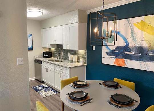 A modern kitchen with a dining table at Latitude at Riverchase, Alabama, 35216