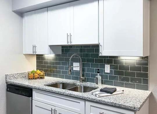 A kitchen with white cabinets and a granite countertop. at Latitude at Riverchase, Hoover