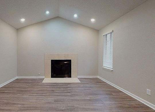 A room with a fireplace and wood flooring. at Spalding Vue, Peachtree Corners, 30092