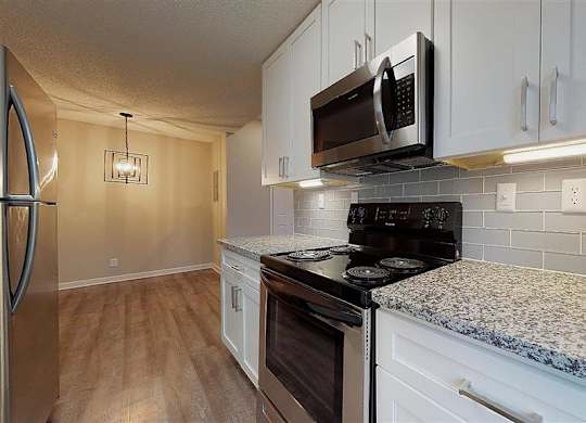 A kitchen with a black microwave above the stove. at Vue on Medlock, Peachtree Corners, GA, 30092