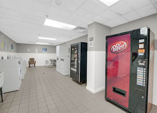 Pepper vending machine is in a room with a washer and dryer at Fullerton Court Apartments, Illinois 60614