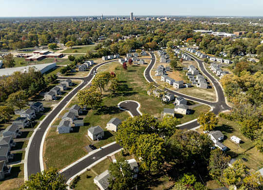 A bird's eye view of a residential area with curved roads and houses at Poplar Place Apartments, Illinois
