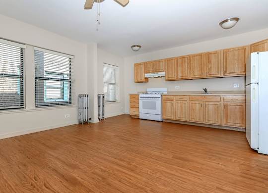 A kitchen with wooden cabinets and a white refrigerator at Sheridan Park, Chicago, IL 60640