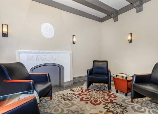 A living room with a fireplace and leather chairs at Sheridan Park, Chicago, IL