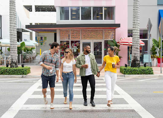 Four people are walking across a crosswalk. at Palma, Florida