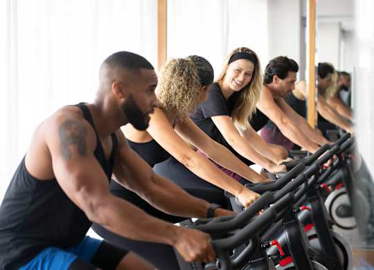 A group of people are working out on exercise bikes in a bright room. at Palma, Doral