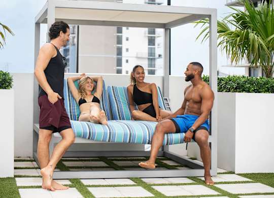 A group of people are sitting and standing on a patio. at Palma, Florida
